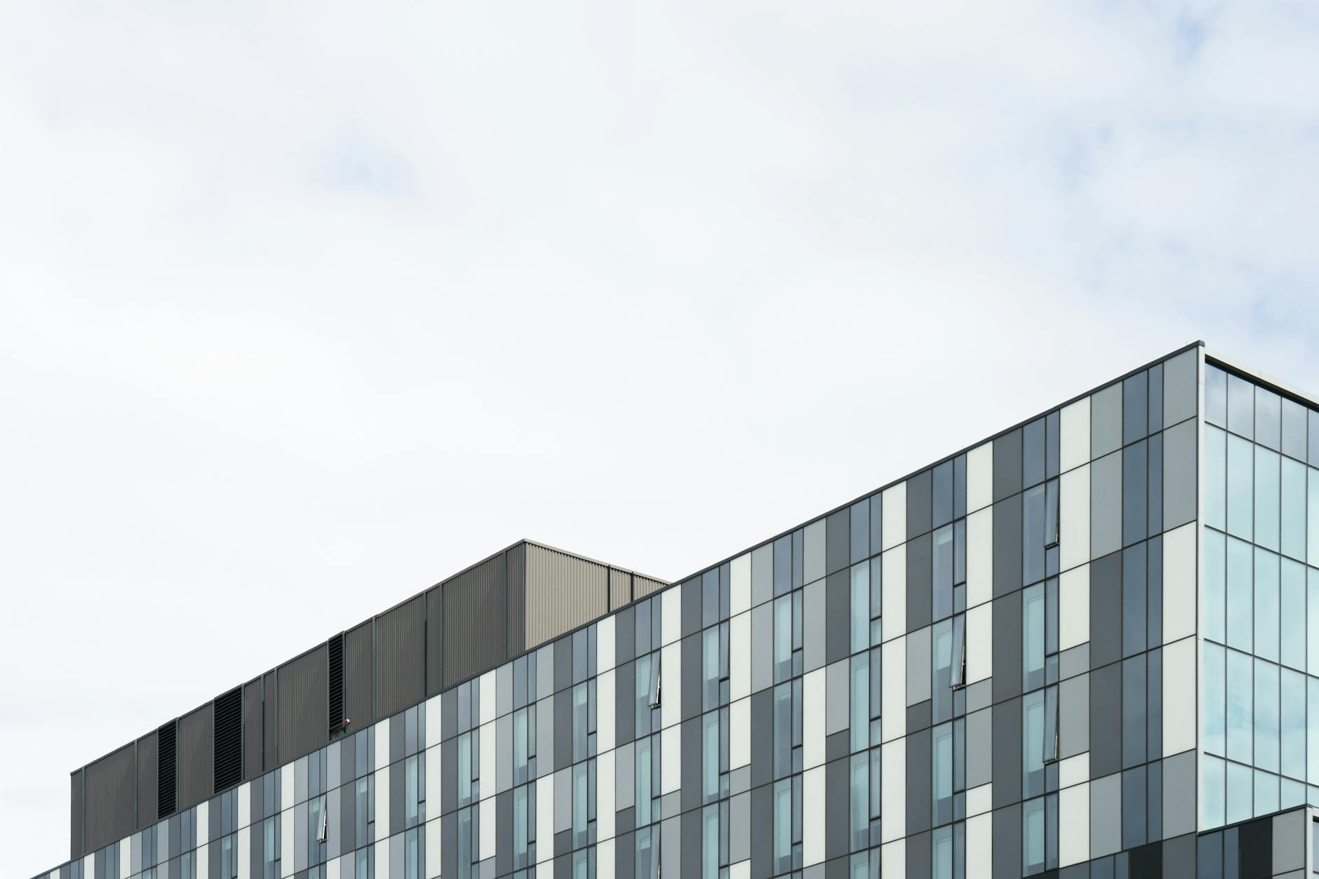 Contemporary glass office building exterior showcasing geometric patterns and modern architecture.